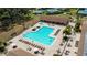 Aerial view of a resort-style pool with chairs and a covered area at 3843 Tarpon Pointe Cir, Palm Harbor, FL 34684