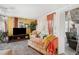 Cozy living room featuring a plaid chaise lounge, television, and bright yellow walls at 585 Sky Harbor Dr # 416, Clearwater, FL 33759