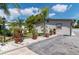 Home exterior featuring landscaping and a long driveway leading to the side entrance at 6213 Sheldon Rd, Tampa, FL 33615