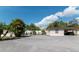 Single-story home featuring a large paved parking area and mature landscaping at 6213 Sheldon Rd, Tampa, FL 33615