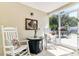 Enclosed patio with rocking chairs and sliding glass doors leading to backyard at 6213 Sheldon Rd, Tampa, FL 33615
