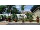 Landscaped front yard featuring a well-manicured garden with potted plants and a decorative statue at 6213 Sheldon Rd, Tampa, FL 33615