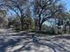 View of the Eiland Park Townhomes entrance sign, surrounded by mature trees and lush landscaping, creating a welcoming atmosphere at 6359 Timberly Ln, Zephyrhills, FL 33542