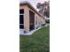 Exterior view of a home with a manicured lawn, white gravel, and plantings near the building at 6359 Timberly Ln, Zephyrhills, FL 33542