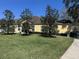 Rear exterior featuring a screened lanai, a lush green yard and mature landscaping at 6359 Timberly Ln, Zephyrhills, FL 33542