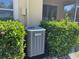 Exterior shot of a newer model Lennox central air conditioning unit surrounded by green bushes at 6359 Timberly Ln, Zephyrhills, FL 33542