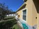 Side view of a house with a well-kept lawn, white gravel, a small window and yellow siding at 6359 Timberly Ln, Zephyrhills, FL 33542