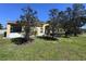 Rear exterior featuring a screened lanai, a lush green yard and mature landscaping at 6359 Timberly Ln, Zephyrhills, FL 33542