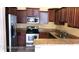 Well-lit kitchen featuring stainless steel appliances, granite countertops, and dark wood cabinetry at 6359 Timberly Ln, Zephyrhills, FL 33542