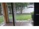 Screened lanai overlooking fenced backyard with lush green grass and landscaping at 6359 Timberly Ln, Zephyrhills, FL 33542