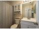 Clean bathroom featuring a shower with striped curtain and white vanity at 720 Earls Ct, Safety Harbor, FL 34695