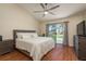 Bright bedroom with wood floors, ceiling fan and sliding glass door to the backyard at 720 Earls Ct, Safety Harbor, FL 34695