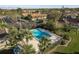 Aerial view of a refreshing community pool area with surrounding palm trees and ample lounge chairs at 720 Earls Ct, Safety Harbor, FL 34695