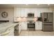 Modern kitchen with stainless steel appliances, granite counters, white cabinets, and tile floors at 720 Earls Ct, Safety Harbor, FL 34695