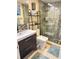 Modern bathroom featuring dark vanity, glass enclosed shower and decorative shelving at 8911 Blind Pass Rd # 220, St Pete Beach, FL 33706