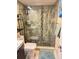 Bathroom shower featuring rock floor and tiled walls at 8911 Blind Pass Rd # 220, St Pete Beach, FL 33706