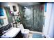 Updated bathroom featuring a walk-in shower with pebble flooring and glass door, a sleek vanity, and a large mirror at 8911 Blind Pass Rd # 220, St Pete Beach, FL 33706
