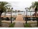 View of a private dock with boat slips framed by palm trees, and scenic waterfront views at 8911 Blind Pass Rd # 220, St Pete Beach, FL 33706