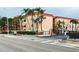 The condo building has a peach exterior, black fence, and tropical trees at 8911 Blind Pass Rd # 220, St Pete Beach, FL 33706