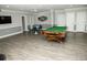 Spacious game room features a pool table, seating area, and modern flooring at 8911 Blind Pass Rd # 220, St Pete Beach, FL 33706