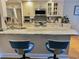 Kitchen with stainless steel appliances, neutral granite counters and bar stool seating at 8911 Blind Pass Rd # 220, St Pete Beach, FL 33706