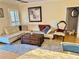 Living room with white leather sofas, wooden chest coffee table, and neutral rug at 8911 Blind Pass Rd # 220, St Pete Beach, FL 33706