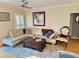 Cozy living room with white leather couch, area rug, fan, and natural light at 8911 Blind Pass Rd # 220, St Pete Beach, FL 33706
