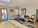 Comfortable living room featuring a white sectional sofa, trunk coffee table, and access to the balcony at 8911 Blind Pass Rd # 220, St Pete Beach, FL 33706