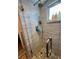 Modern shower with wavy, light gray walls, rainfall shower head, handheld sprayer, and pebble floor at 8911 Blind Pass Rd # 220, St Pete Beach, FL 33706