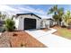 Charming home with a well-manicured lawn and a black garage door at 11105 Zimmerman Rd, Port Richey, FL 34668