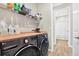 Laundry room featuring front load washer and dryer with wood countertop and storage shelving at 13659 Stansil Ave, Odessa, FL 33556