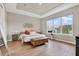 Serene main bedroom with tray ceiling, laminate wood flooring, a leather ottoman, and large picture window at 13659 Stansil Ave, Odessa, FL 33556