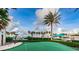 A pristine putting green for practicing your short game, amidst a beautiful landscape with tall palm trees at 1520 Gulf Blvd # 1407, Clearwater Beach, FL 33767