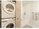 Modern bathroom featuring a shower-tub, white subway tile, and stacked washer and dryer at 2001 E 2Nd Ave # 20, Tampa, FL 33605