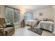 Bright bedroom with natural light and two twin beds, featuring a comfortable chair and neutral decor at 2042 Australia W Way # 66, Clearwater, FL 33763