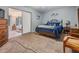 Comfortable bedroom featuring blue accents, soft carpet, and a doorway to an adjacent room with twin beds at 2042 Australia W Way # 66, Clearwater, FL 33763