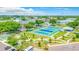 Aerial view of the community's blue tennis courts, picnic tables, and parking in a lush green setting at 2042 Australia W Way # 66, Clearwater, FL 33763