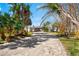 Paver driveway leading to a modern home surrounded by lush tropical landscaping, creating an inviting entrance at 2210 Harbor View Dr, Dunedin, FL 34698