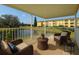 Relaxing balcony view with wicker chairs overlooking the pond, trees, and building at 2220 Spanish Dr # 4, Clearwater, FL 33763