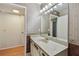 Bathroom with a marbled sink vanity and a bright, vanity mirror with decorative lighting at 2220 Spanish Dr # 4, Clearwater, FL 33763