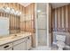 Full bathroom featuring wallpapered walls, a single sink vanity, and a glass-enclosed shower at 2220 Spanish Dr # 4, Clearwater, FL 33763