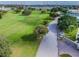 Aerial view of a lush green golf course with a paved road and trees at 2220 Spanish Dr # 4, Clearwater, FL 33763