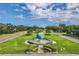 Scenic aerial view of community entrance with well-manicured lawns, globe water feature and mature trees at 2351 Irish Ln # 43, Clearwater, FL 33763