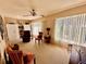 Bright living room boasts large windows, neutral carpet, and a ceiling fan, offering ample natural light and comfort at 2351 Irish Ln # 43, Clearwater, FL 33763