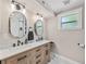 Bathroom featuring double sinks, framed mirrors, modern lighting, and decorative tile floors and shower at 3002 N 16Th St, Tampa, FL 33605
