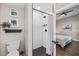 Bathroom with tiled shower and commode, adjacent to a bedroom featuring a ceiling fan and hardwood floors at 3002 N 16Th St, Tampa, FL 33605