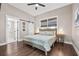 Bedroom with a comfortable bed, hardwood floors, neutral paint, and a bathroom featuring a sliding barn door at 3002 N 16Th St, Tampa, FL 33605