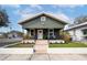 Charming home exterior features a covered front porch, green paint, white trim and manicured landscaping at 3002 N 16Th St, Tampa, FL 33605