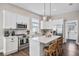 Modern kitchen with white cabinetry, stainless steel appliances, quartz countertops, and an island with seating at 3002 N 16Th St, Tampa, FL 33605