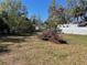 Backyard view featuring a pile of dead branches, mature trees, and partial fence line at 306 5Th Nw Ave, Ruskin, FL 33570